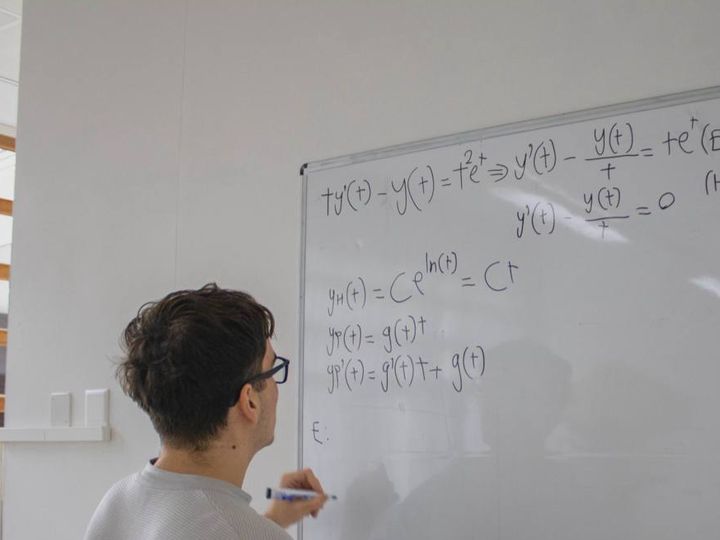 Ученик решает дифференциальное уравнение у доски